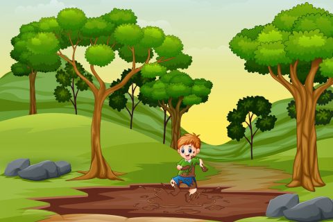 A young boy playing in a mud puddle